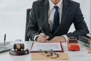 Judge male hand with car and documents and hammer